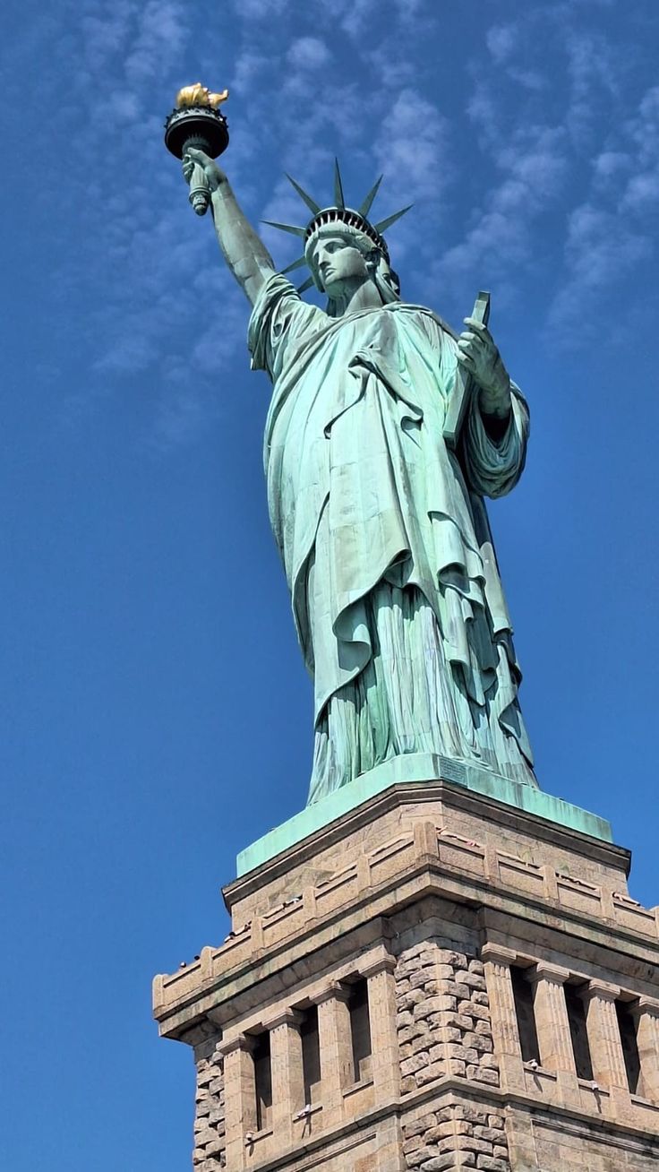 the statue of liberty is shown against a blue sky