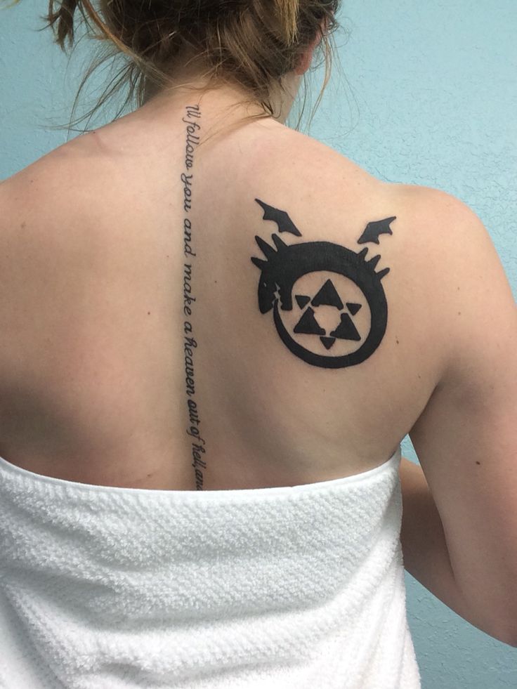 the back of a woman's shoulder with a triforce symbol tattoo on it