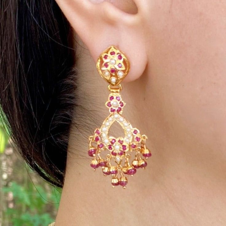 Featuring a pair of dainty danglers made in sterling silver with gold plating. The studded stones comprise ruby like red stones and freshwater pearls. The hanging beads are real rubies. The earrings close with a bombay screw. Jadau Earrings, 22k Gold Jewelry Necklaces, Gold Jewellry, 22k Gold Jewelry, Hanging Beads, Red Stones, Pearl Necklace Set, Gold Jewelry Necklace, Emerald Necklace