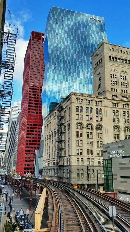 a train track running through a city with tall buildings in the background