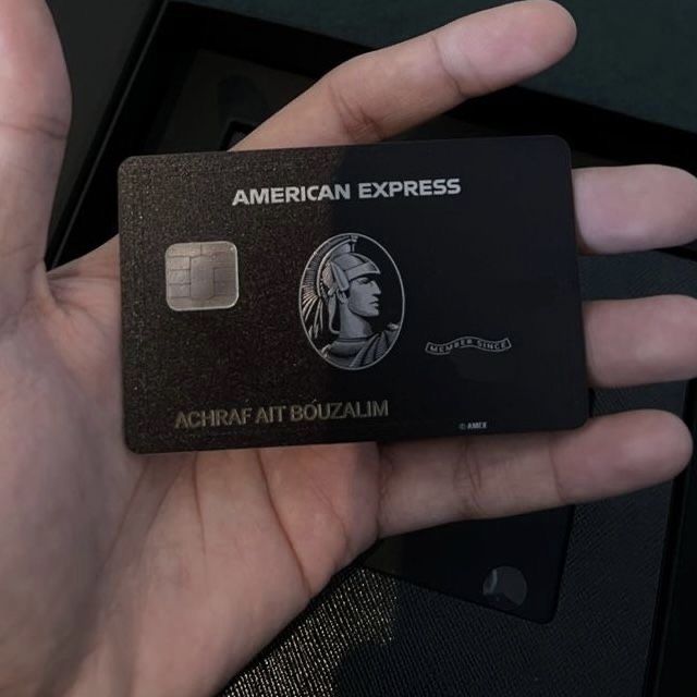 a hand holding an american express credit card