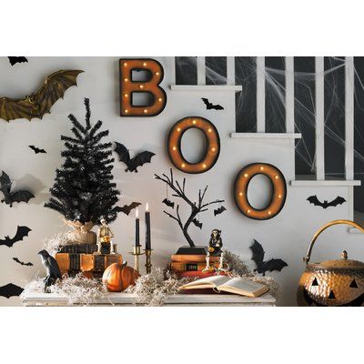 halloween decorations on the wall with bats and pumpkins in front of them, along with boo's