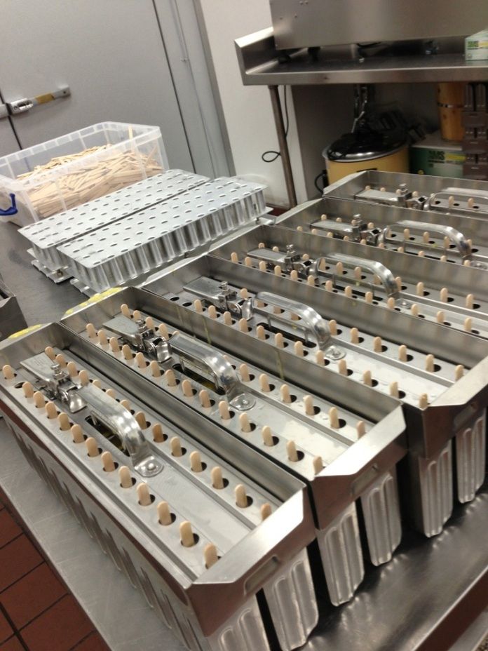 an assembly line in a factory with plastic containers on the conveyor belt