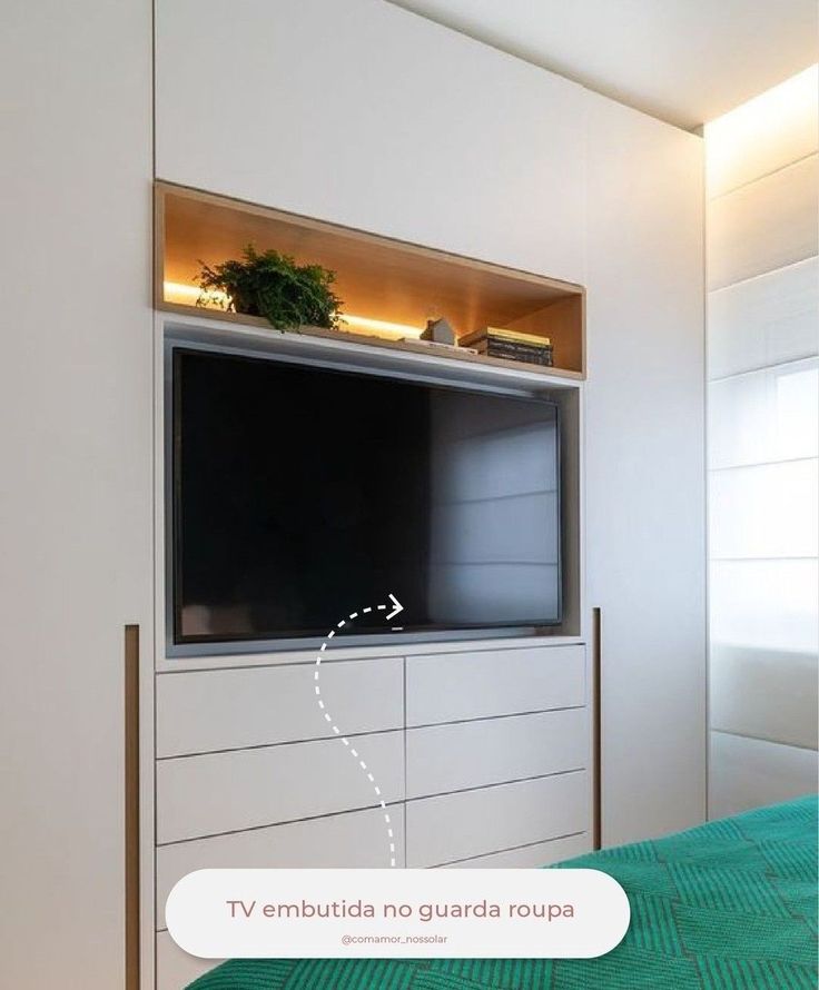 a flat screen tv mounted to the side of a white cabinet in a living room