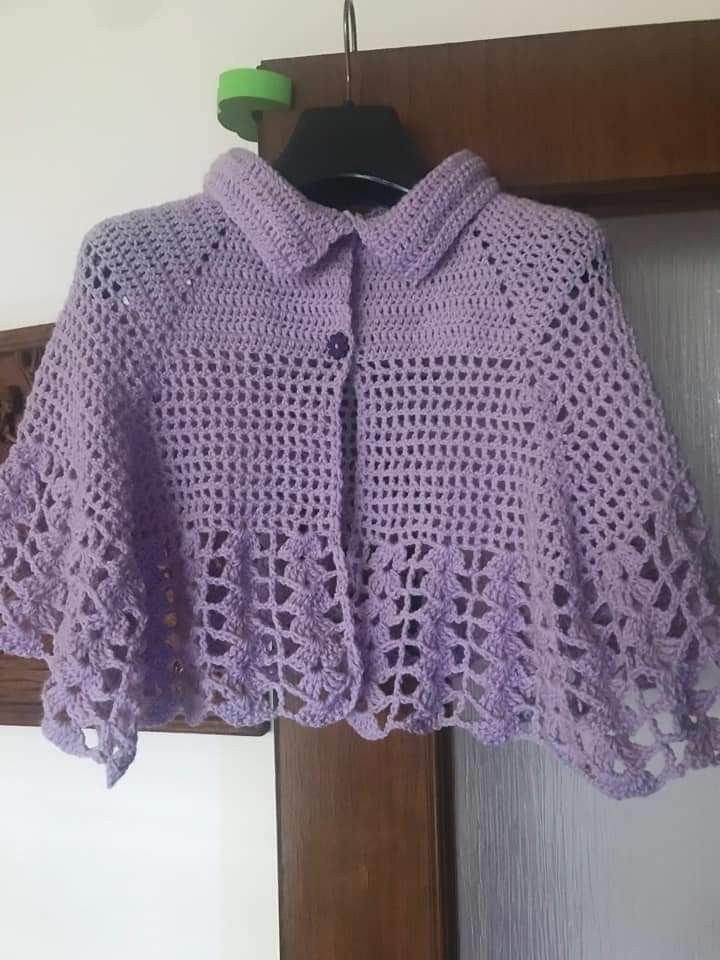 a purple crocheted sweater hanging from a hook