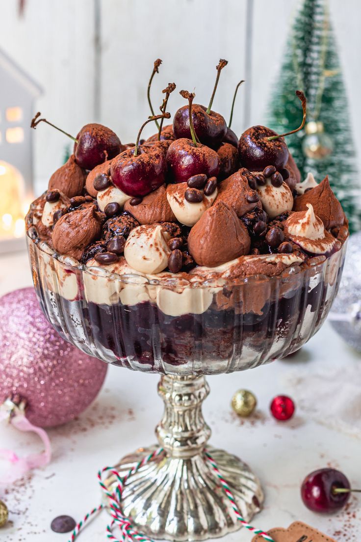 a dessert dish with cherries, chocolate and marshmallows in it on a table