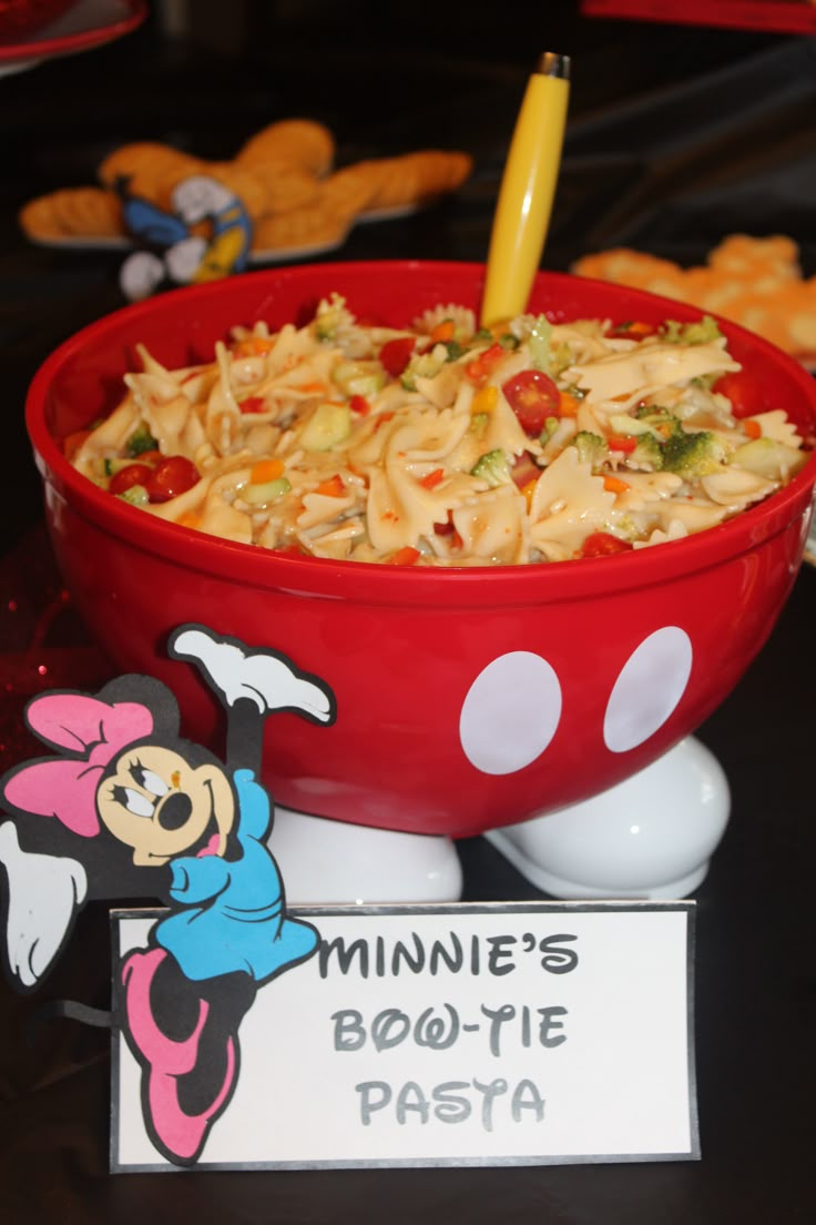 there is a bowl of pasta with minnie mouse on it and a sign that says minnie's bowtie pasta