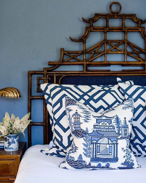 a bed with blue and white pillows on it