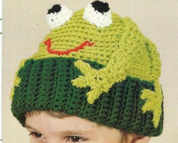 a young boy wearing a knitted frog hat