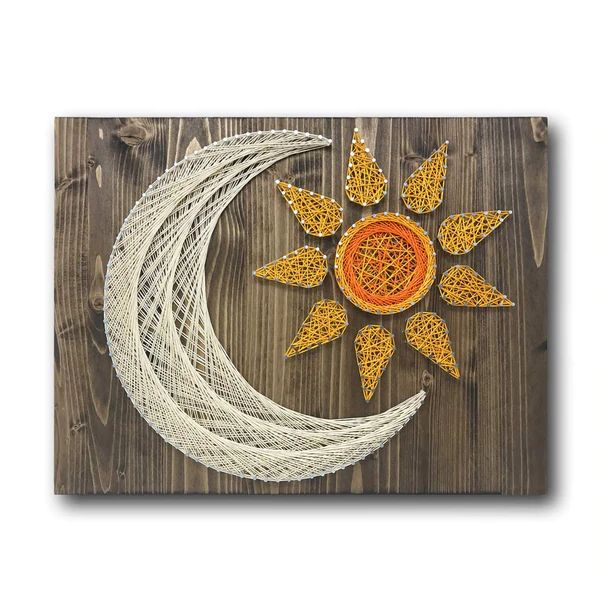 the sun and moon are made out of string on a wooden background with white thread