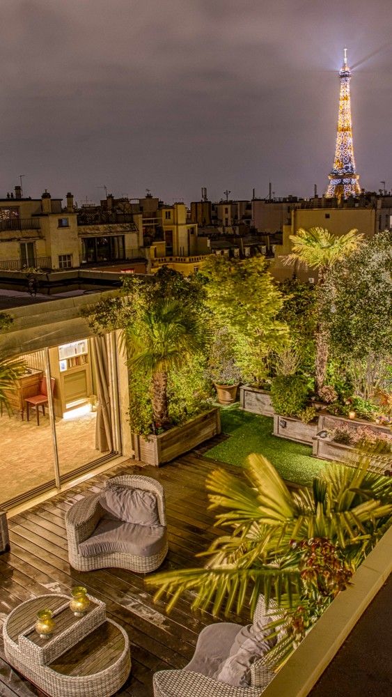 an outdoor patio with wicker furniture and the eiffel tower in the background