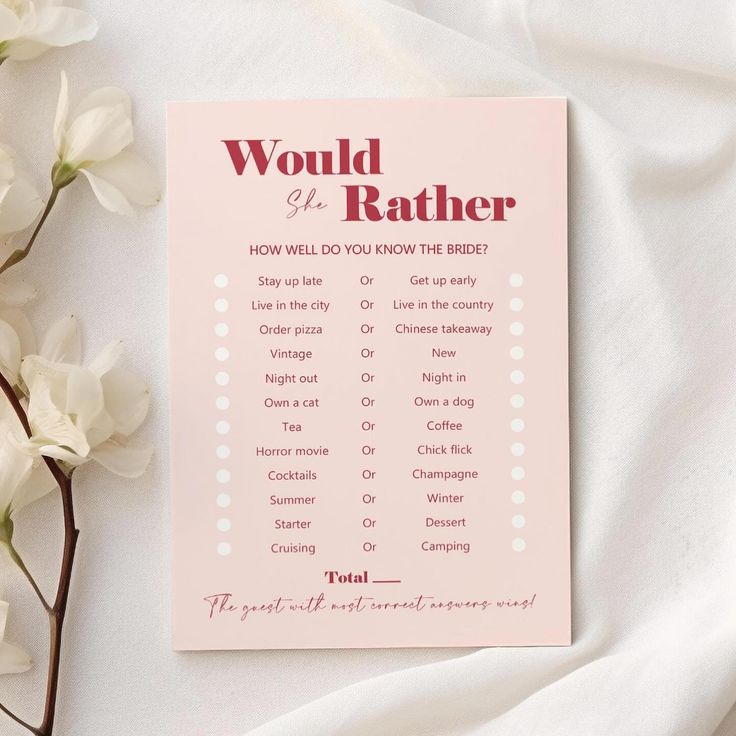 a pink book sitting on top of a bed next to white flowers and a plant