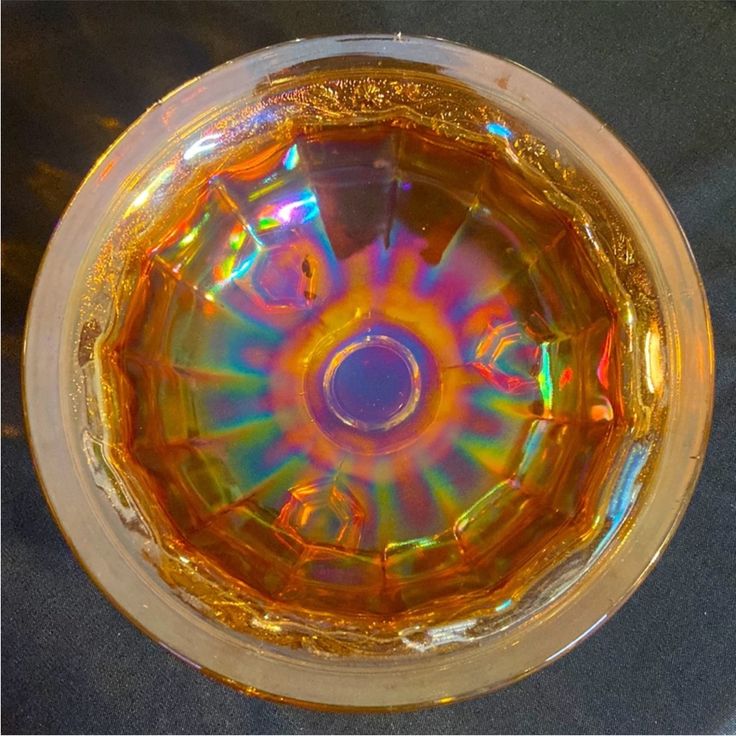 the inside of a glass bowl that is yellow and has an iridescent color