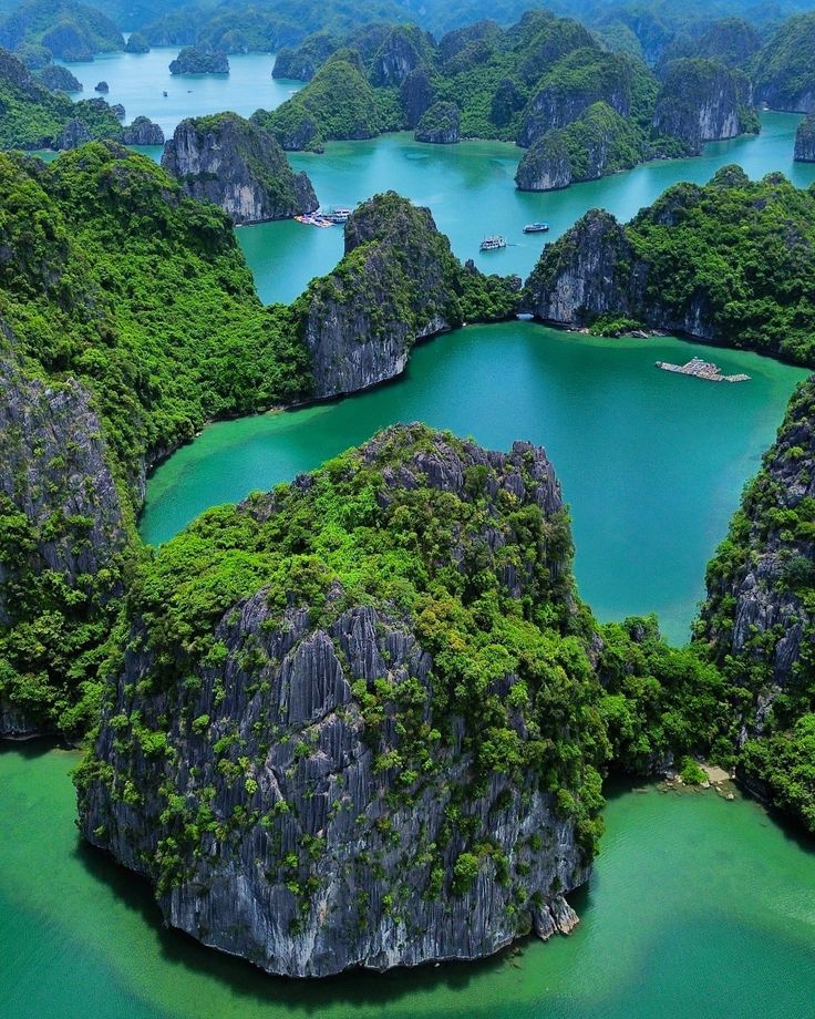 an aerial view of the water surrounded by rocks and green vegetation, with several islands in the background