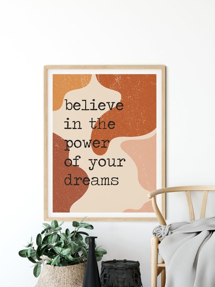 a poster with the words believe in the power of your dreams hanging above a chair