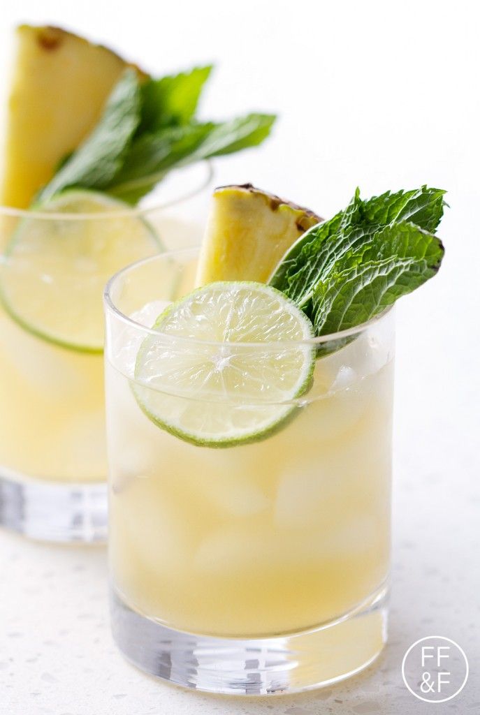 two glasses filled with pineapple margaritas and garnished with mint