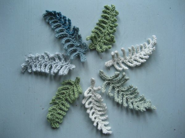 a group of crocheted leaves sitting on top of a table