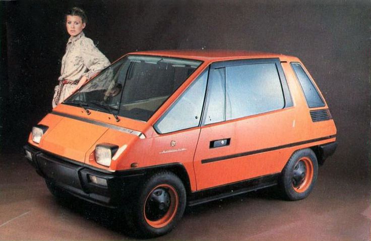 an orange car with a woman standing on top