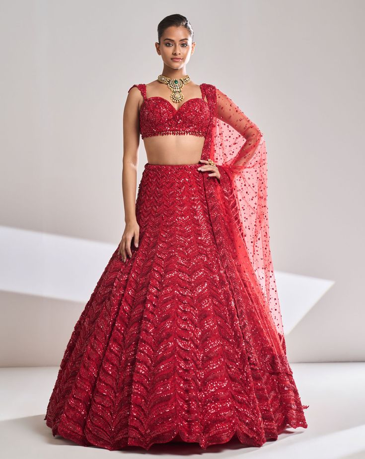 This red lehenga set features all over tonal sequin emboidery in a leaf like pattern. The outfit is paired with a strappy blouse and a four sided embroidered net dupatta.From Seema Gujral’s Night at the Opera collectionDELIVERY TIMEPlease allow 8-12 weeks for your outfit to arrive.FABRIC DETAILSNet Professional cleaning only Red Sequin Lehenga, Strappy Blouse, Sequin Lehenga, Seema Gujral, Sari Design, Reception Lehenga, Wedding Lehengas, Indian Bride Outfits, Red Lehenga