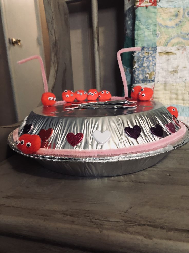 a tin foil tray with hearts and eyes on it sitting on top of a table