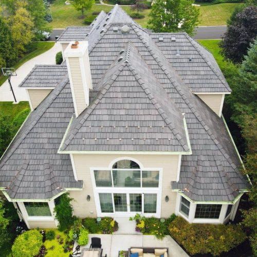 an aerial view of a large house in the middle of some trees and bushes,