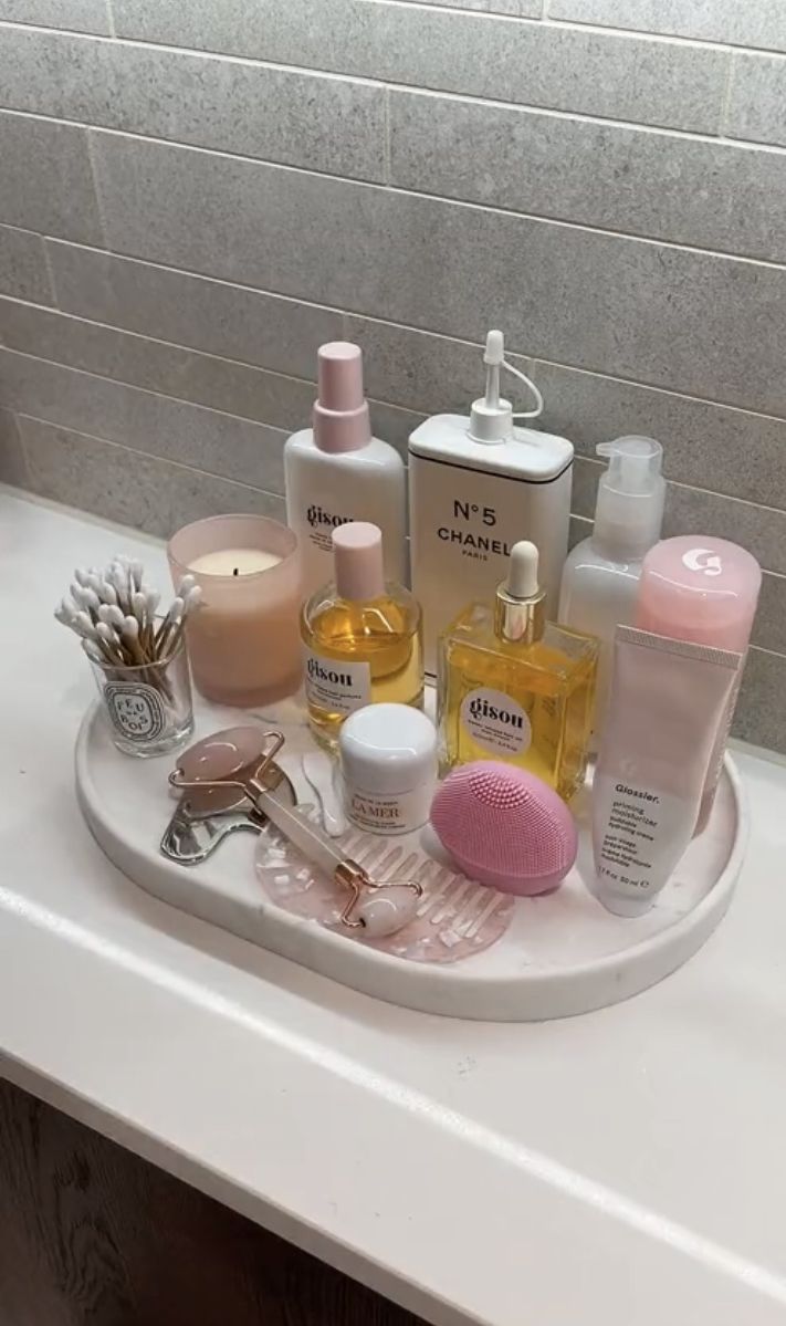 a bathroom sink filled with lots of beauty products and personal care items on top of it