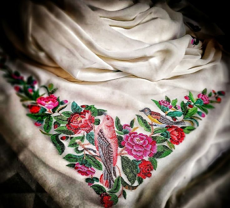 an embroidered scarf with birds and flowers on it