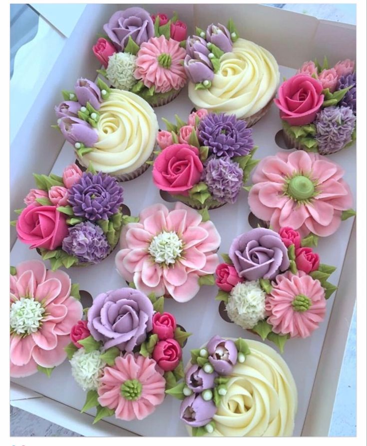 cupcakes decorated with flowers in a box