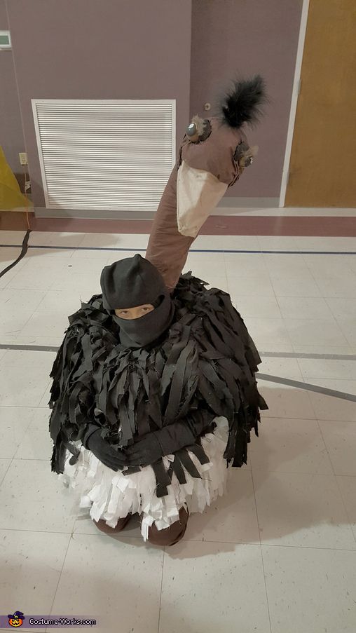 a costume made to look like an ostrich sitting on top of a pile of feathers