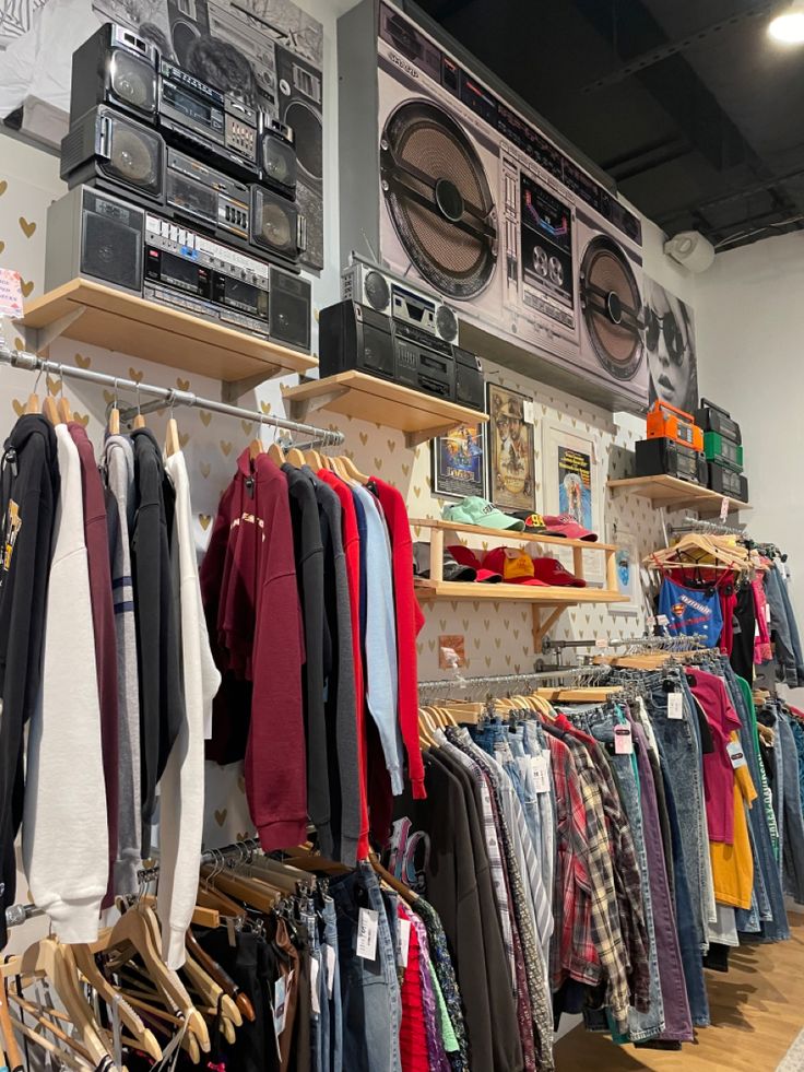 clothes are hanging on shelves in a clothing store, and there is a washer dryer next to it