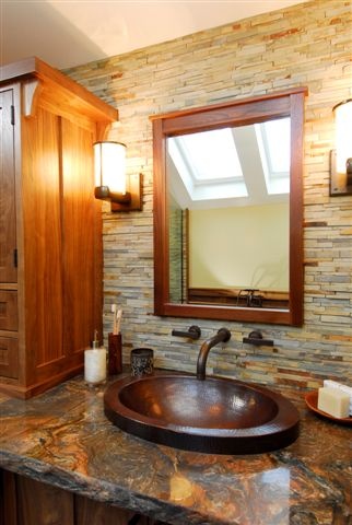 a bathroom with a sink, mirror and wooden cabinetry in it's corner