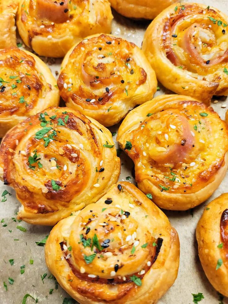 several different types of bread rolls on a tray with parsley sprinkled on top