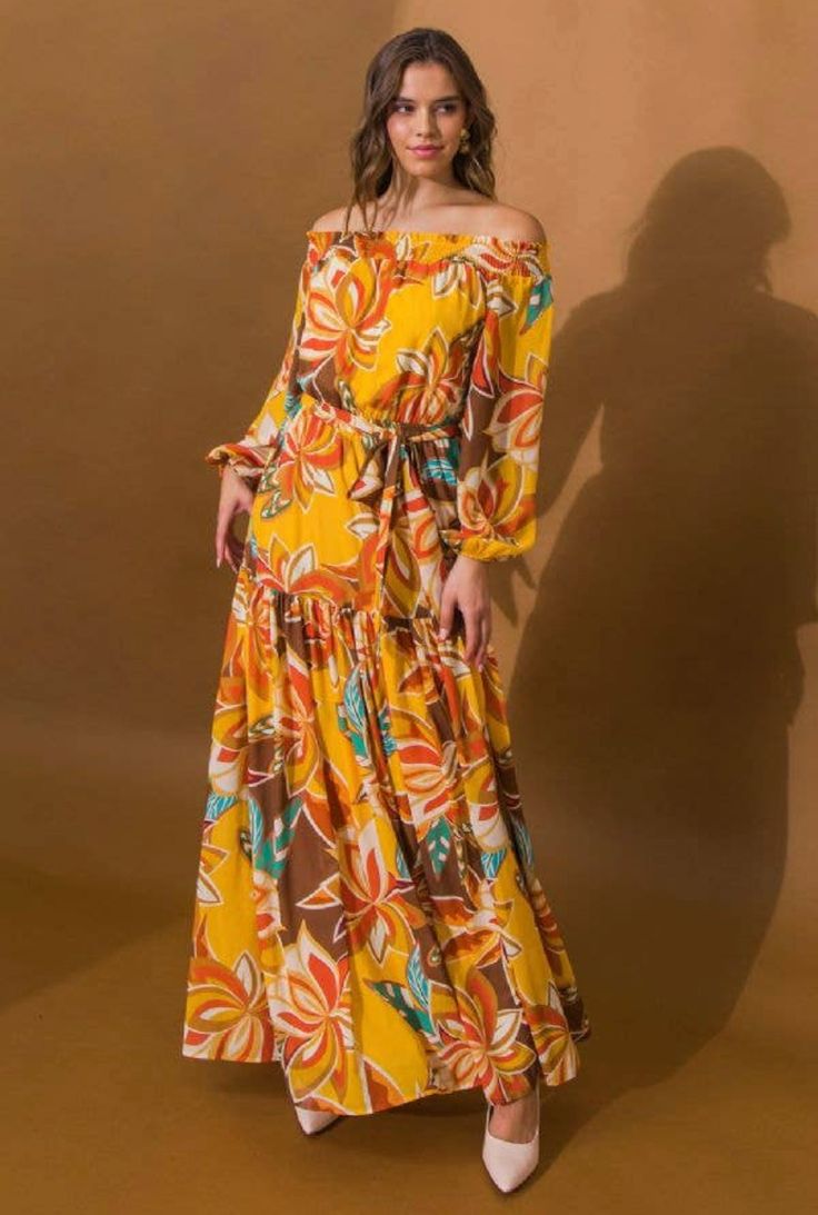 This is a gorgeous brand new full length bold color dress. Popping with floral colors through out! Makes a splendid addition to your seasonal wardrobe. The dress is mustard color, with floral patterns to accent. This beauty has a squared shoulder neckline, smocked bodice, peasant sleeve, elasticized waist, and tiered skirt. It is made of 100% polyester with a 100% polyester lining. Our model is 5’8” and wearing a size small. Her dress is 56” long. This item ships immediately to US addresses! Thi Yellow Bohemian Dress For Fall, Yellow Bohemian Fall Dress, Brown Floral Print Maxi Dress For Vacation, Orange Floral Print Maxi Dress, Fall Vacation Floral Print Maxi Dress, Yellow Bohemian Maxi Dress For Fall, Orange Floral Print Floor-length Maxi Dress, Spring Yellow Maxi Dress With Vibrant Print, Flowy Brown Printed Maxi Dress