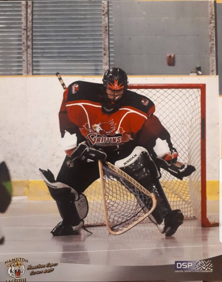 a hockey goalie crouching down in front of the net