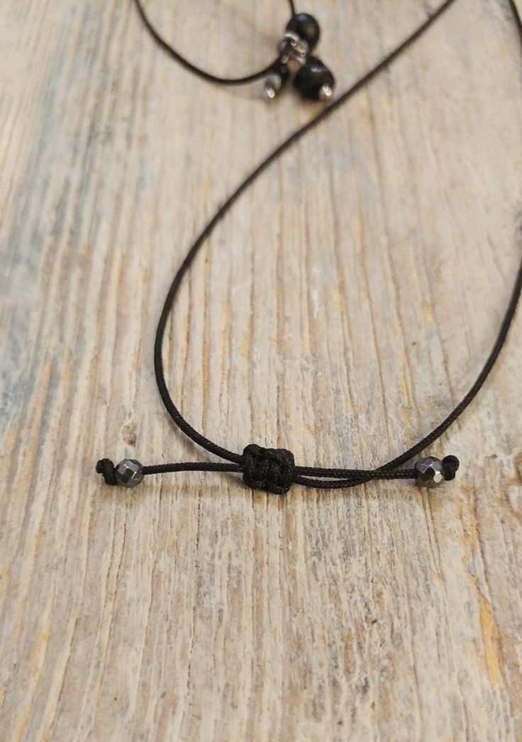 Verstellbare Kette mit schwarzem Turmalin, Onyx, Hämatit Diese Halskette passt sich deinen Bedürfnissen an. Du kannst sie, wie auf den Fotos zu sehen, von lang bis zum kurzen Choker gemacht, tragen. Einfach mittels Schiebeverschluss.Der 3er-Anhänger besteht aus schwarzem Turmalin, Onyx und Hämatit.An den Enden der Textilkordel sind 2 facettierte Hämatitperlen befestigt. Maximale Länge: 75cmDie Metallteile sind aus Edelstahl. Adjustable Hematite Necklace With Black Beads, Black Minimalist Jewelry With Adjustable Cord, Minimalist Silver Necklace With Waxed Cord, Minimalist Necklace With Adjustable Waxed Cord, Minimalist Necklace With Adjustable Length And Waxed Cord, Black Spiritual Choker Necklace, Minimalist Handmade Black Choker, Minimalist Adjustable Jewelry With Black Beads, Minimalist Adjustable Necklace With Waxed Cord