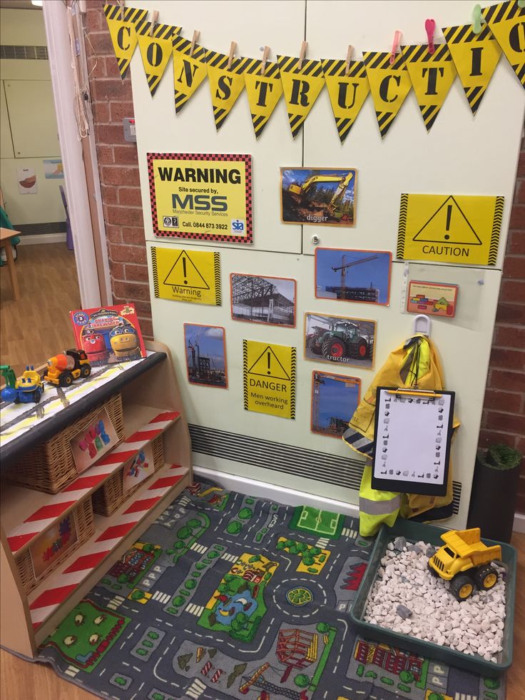 a play area with toys and construction signs on the wall, along with legos