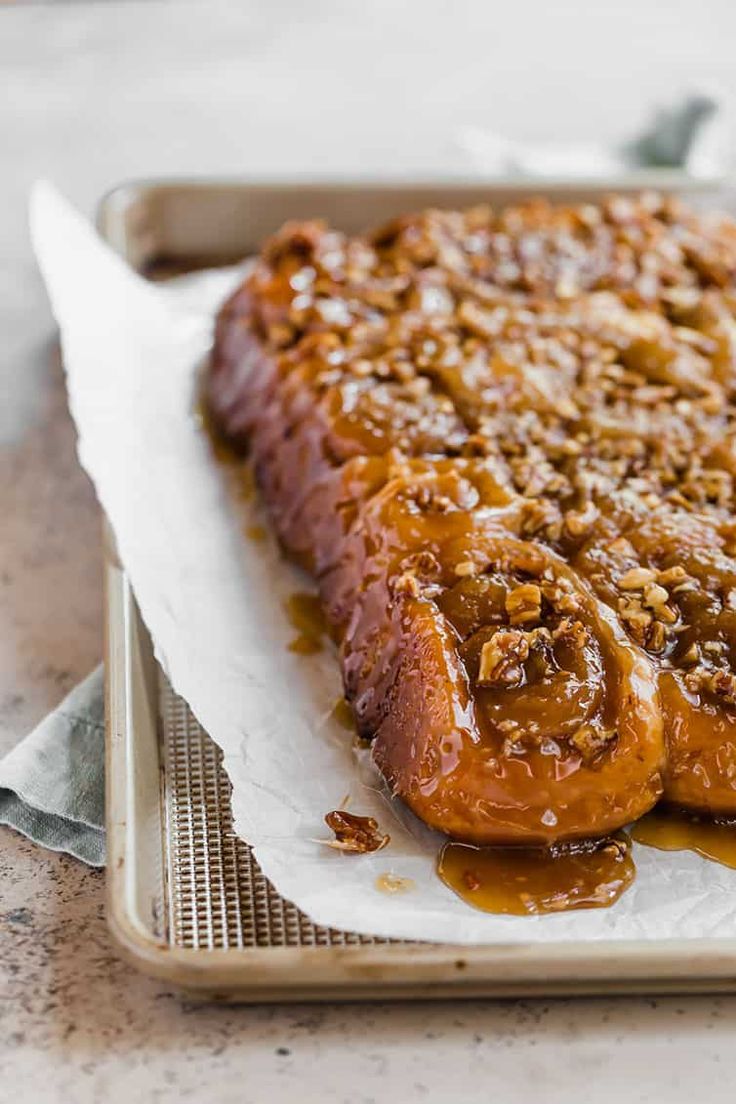 two pieces of bread covered in caramel sauce on top of a piece of parchment paper