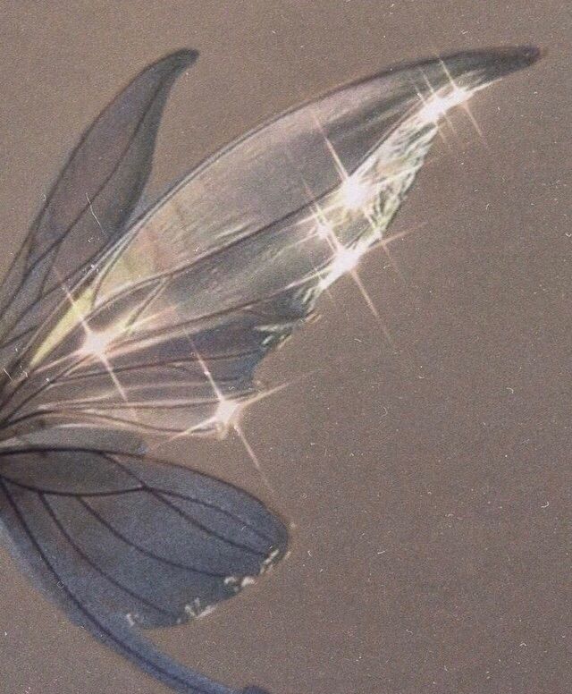 a butterfly flying through the air with its wings spread out and sparkling in the sun