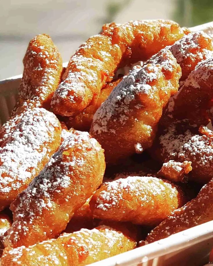 powdered sugar coated doughnuts in a bowl