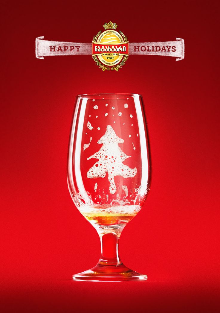 a red wine glass with a white christmas tree on the top and happy holidays written above it