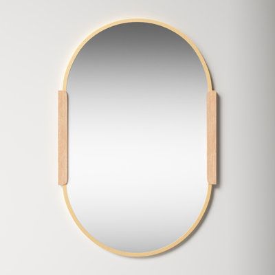 a round mirror with a wooden frame on the wall