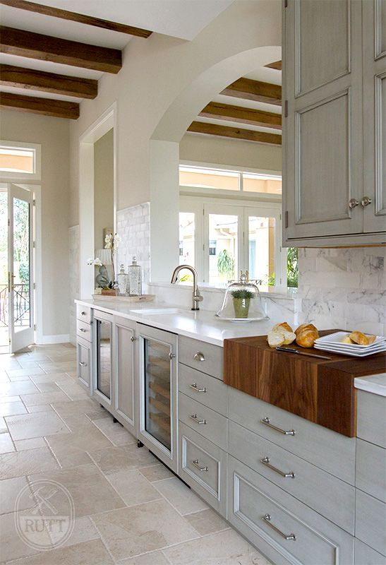 a large kitchen with white cabinets and marble counter tops