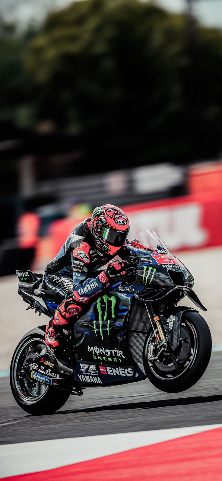 a man riding on the back of a motorcycle down a race track