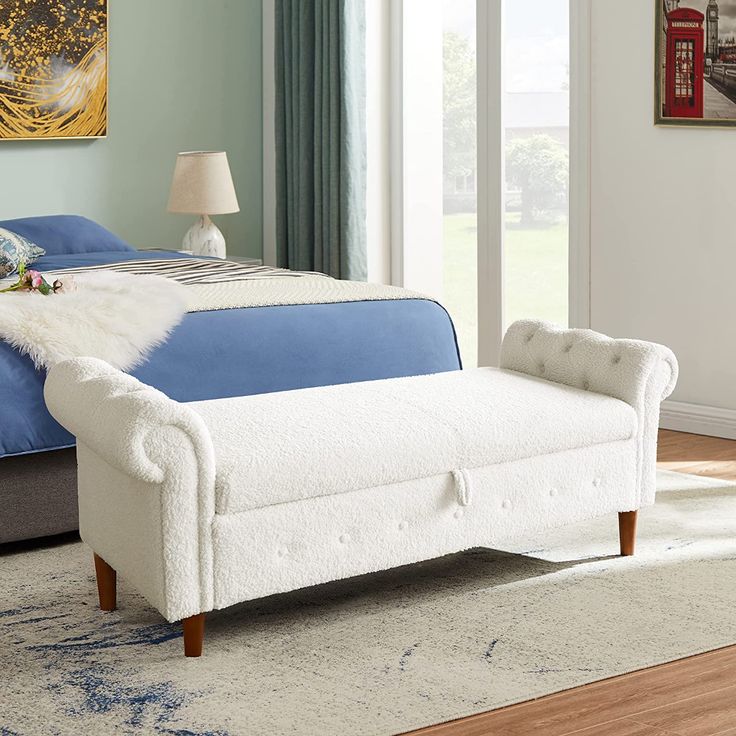 a white bed with blue sheets and pillows