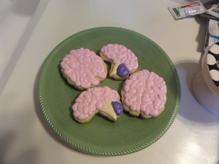 four decorated cookies sitting on top of a green plate