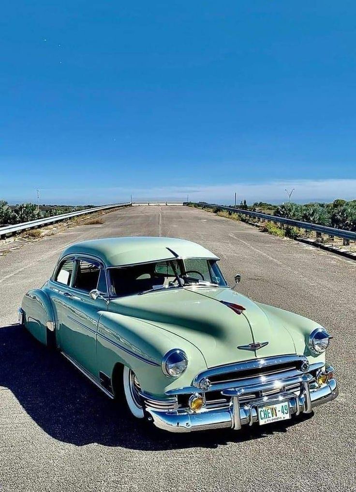 an old car is parked on the side of the road