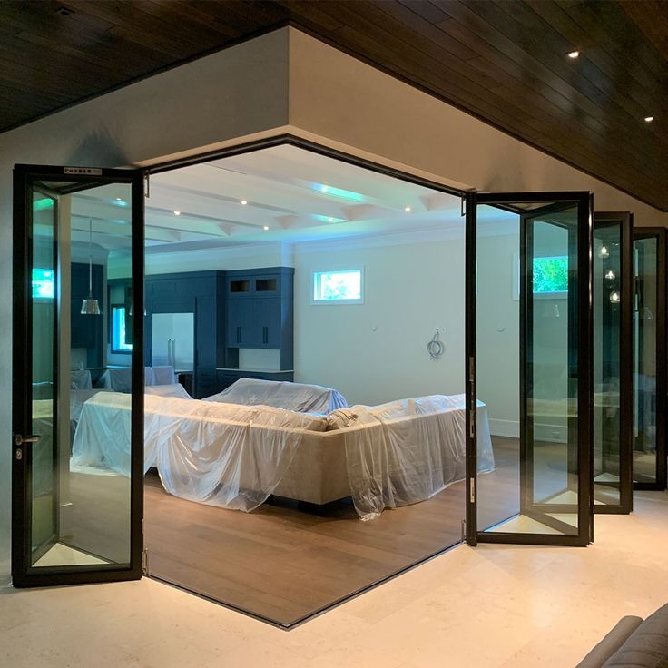 an open room with glass doors and a bed in the middle is seen through it