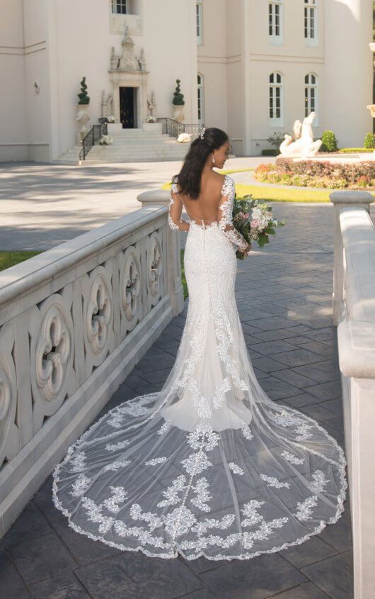 a woman in a wedding dress is standing on a balcony with her back to the camera