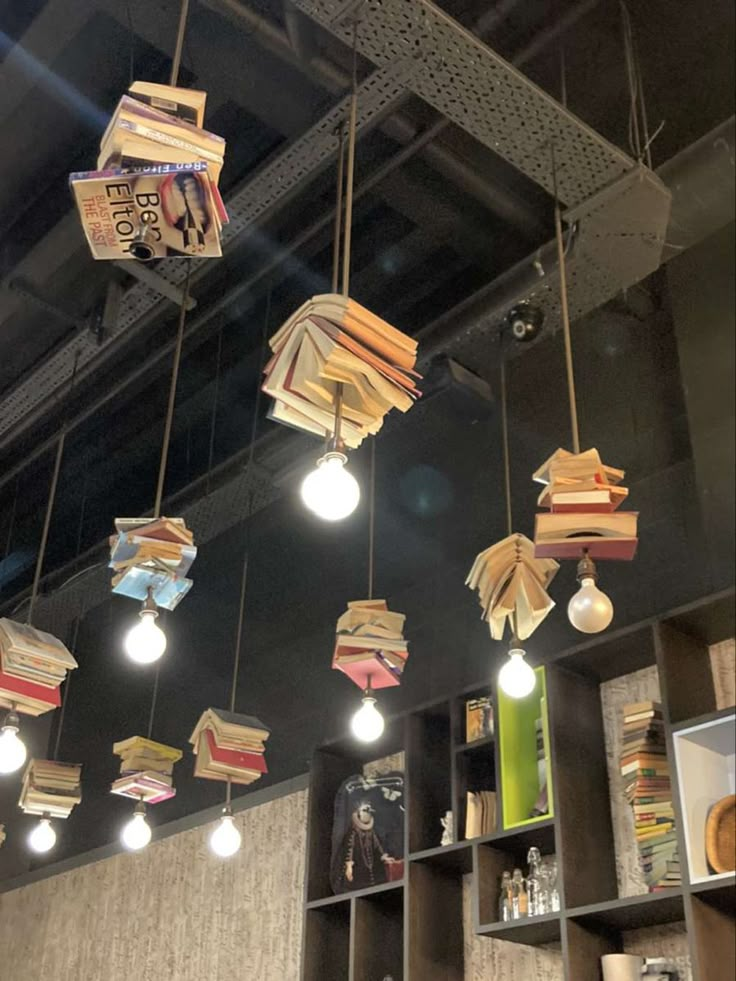 several books are suspended from the ceiling by lights