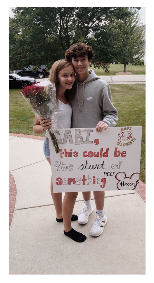 two people standing next to each other holding flowers and a sign that says fail this could be